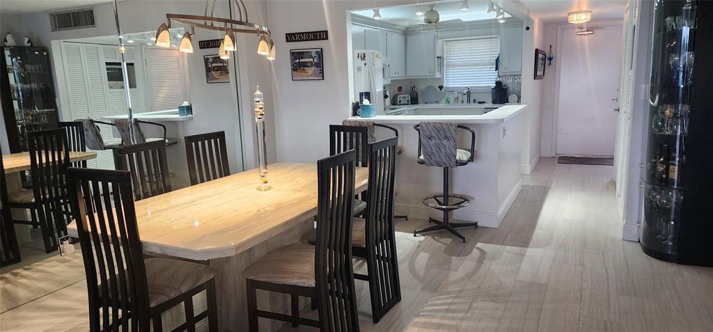 299 North Riverside Drive, Unit 303 Pompano Beach, FL 33062 - Photo 8 of 40 a dining room with furniture and wooden floor