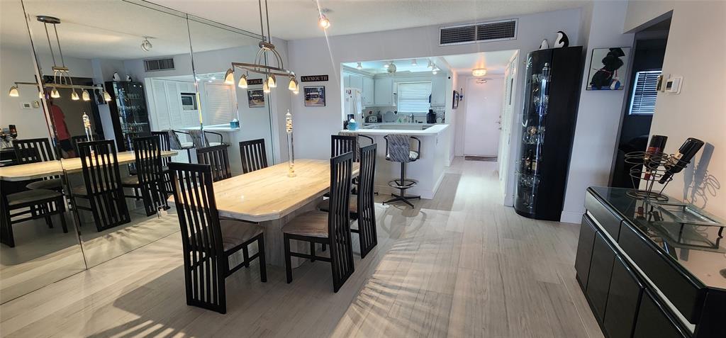 299 North Riverside Drive, Unit 303 Pompano Beach, FL 33062 - Photo 9 of 40 a kitchen with stainless steel appliances granite countertop table chairs and a refrigerator