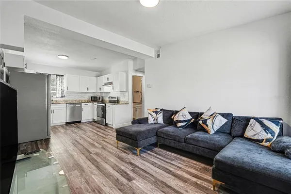 a living room with furniture and kitchen view