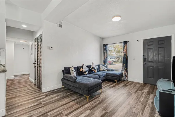 a living room with furniture and a wooden floor