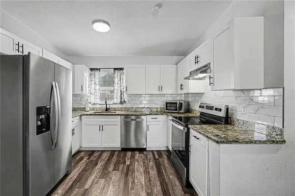 a kitchen with a refrigerator stove and sink