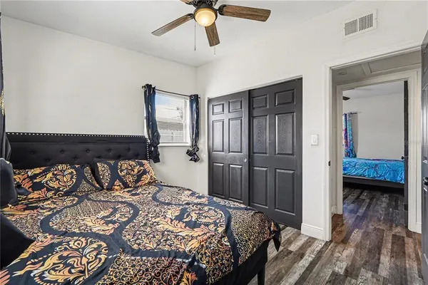 a bedroom with a bed and wooden floor