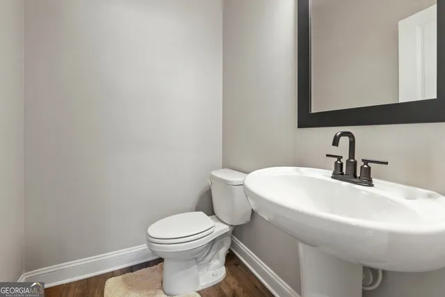 a bathroom with a sink a toilet and mirror