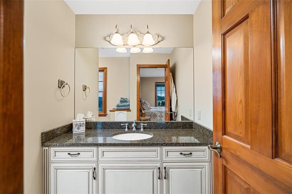 225 Church Road Fombell, PA 16123 - Photo 29 of 45 a bathroom with a granite countertop sink a mirror and a vanity