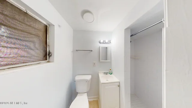 a bathroom with a toilet sink and a mirror