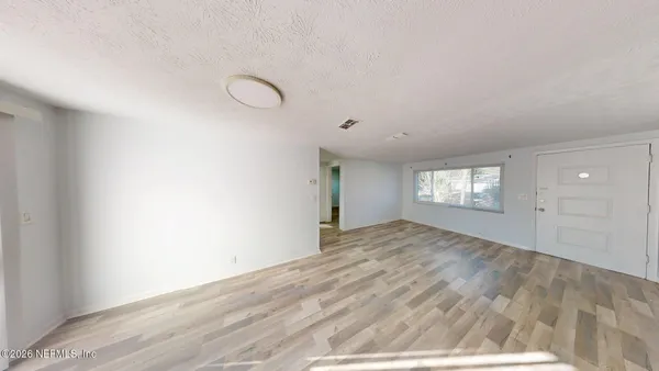 a view of empty room with windows and ceiling fan