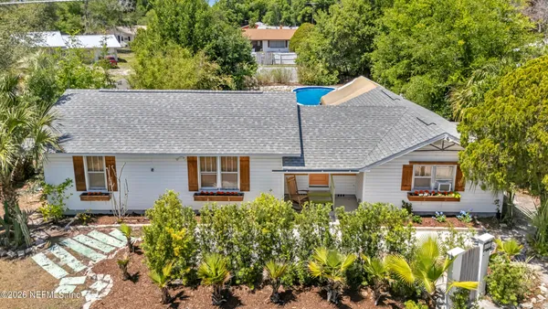 front view of house with a yard and potted plants