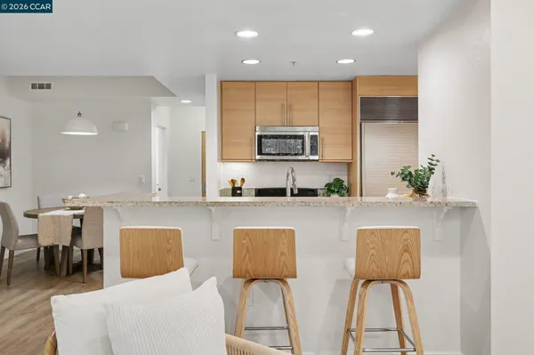 a kitchen with stainless steel appliances granite countertop a white cabinets a sink and a stove