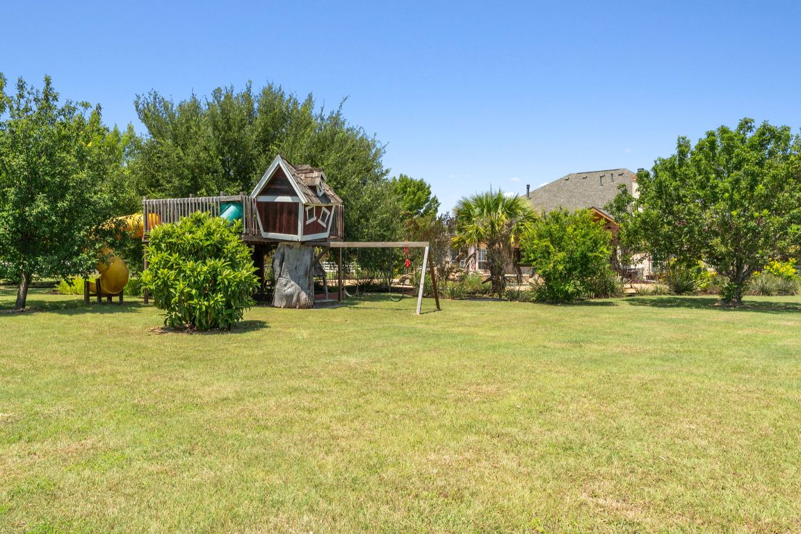 218 Courtnee's Way Georgetown, TX 78626 - Photo 34 of 36 The playscape is thoughtfully designed to feel like a whimsical treehouse, elevated among the mature trees for an adventurous, tucked-away vibe ~
