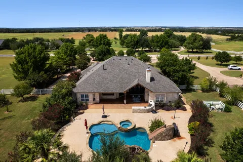 an aerial view of a house with garden space and outdoor seating