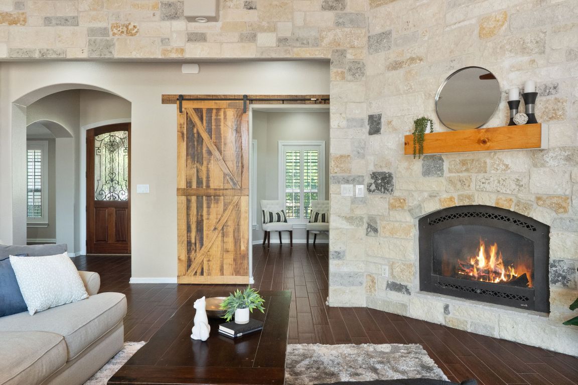 218 Courtnee's Way Georgetown, TX 78626 - Photo 8 of 36 From the living room, the view into the dedicated office is framed by a beautiful custom barn door, offering a glimpse of a bright, private workspace that blends seamlessly with the home’s warm, inviting design ~