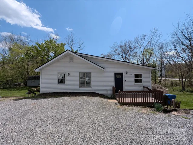 a view of a house with a yard and fence