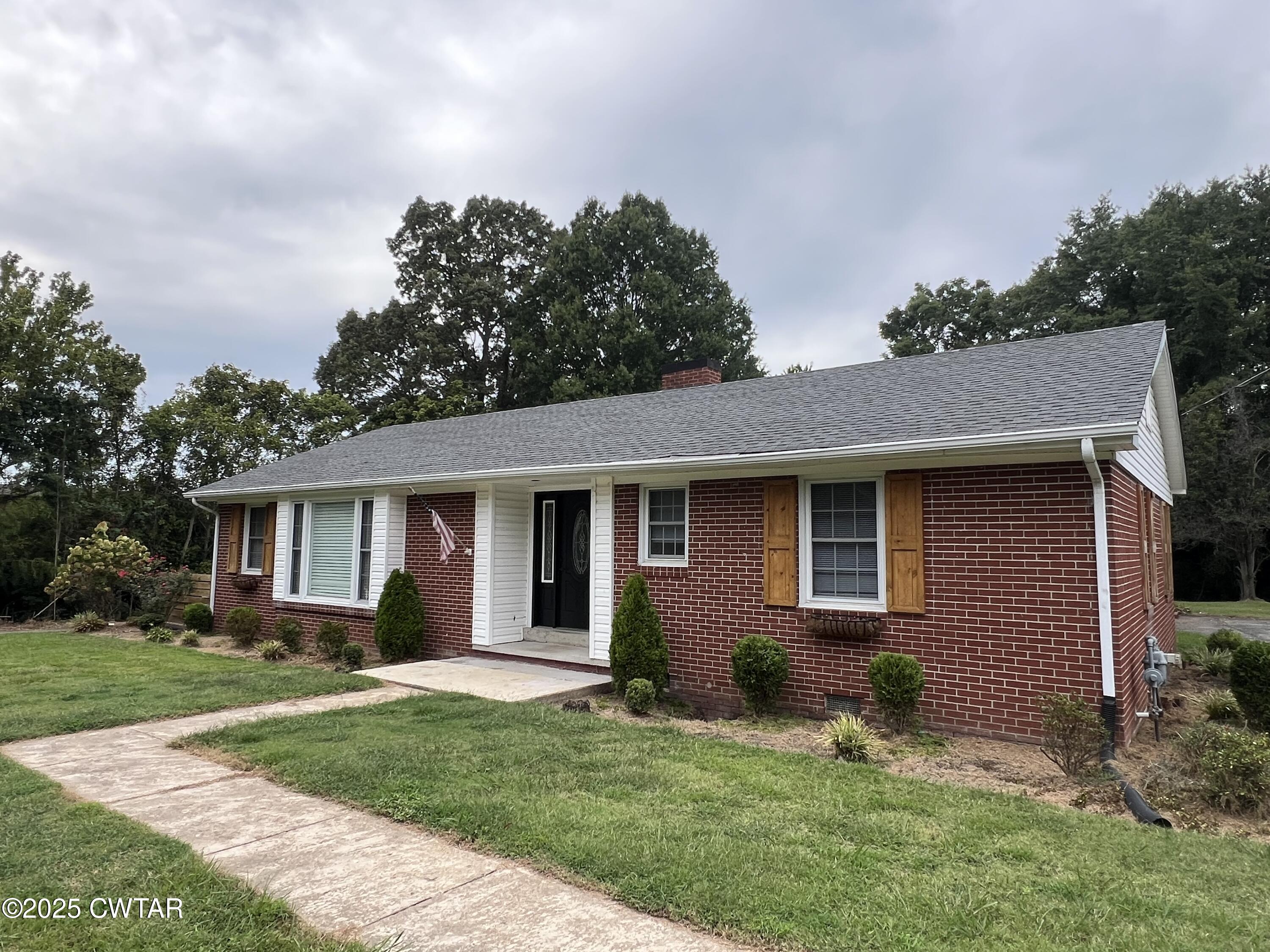 1056 Phelps Lane Milan, TN 38358 - Photo 1 of 17 a backyard of a house with potted plants and large tree