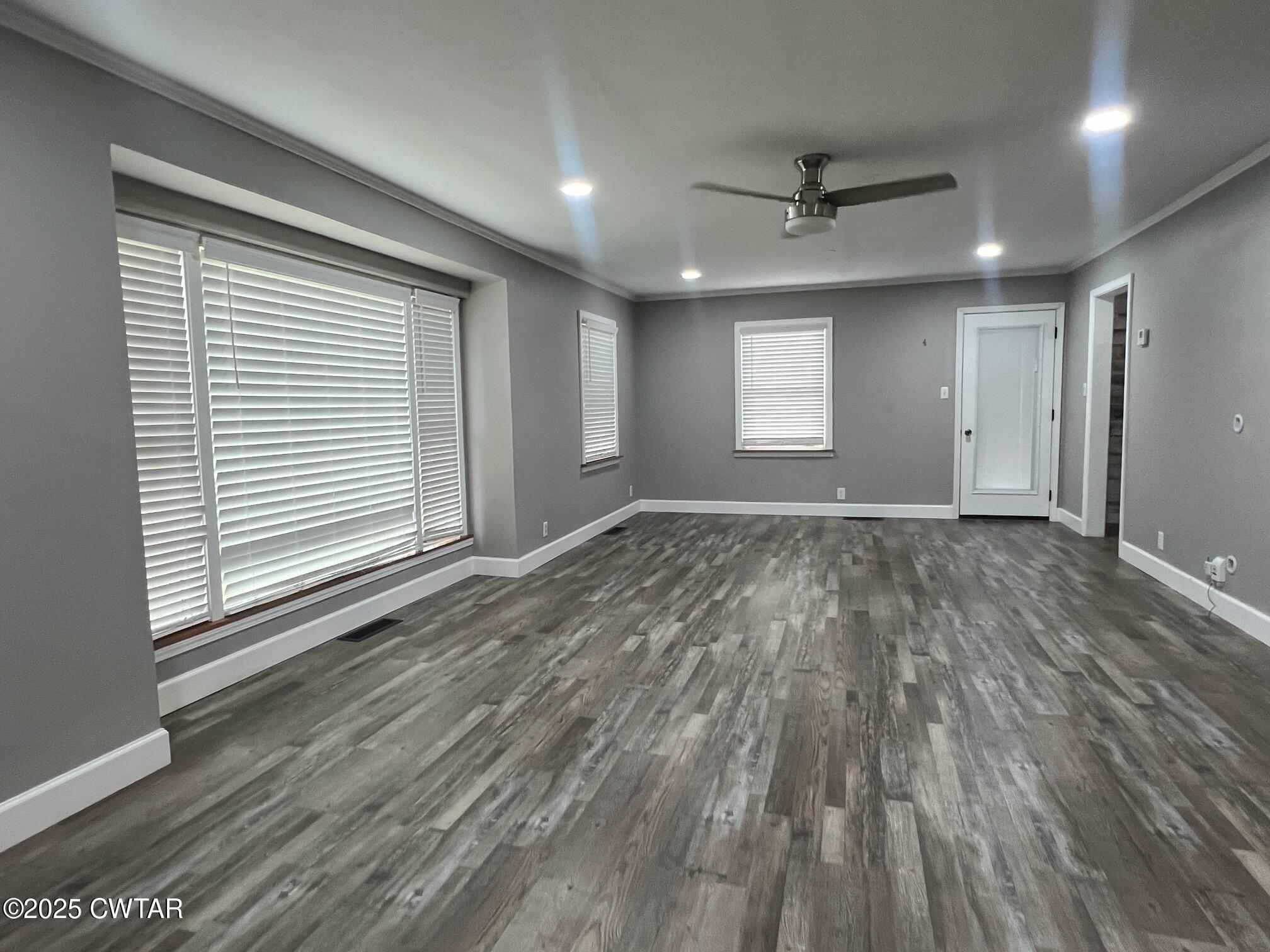 1056 Phelps Lane Milan, TN 38358 - Photo 7 of 17 an empty room with wooden floor and windows