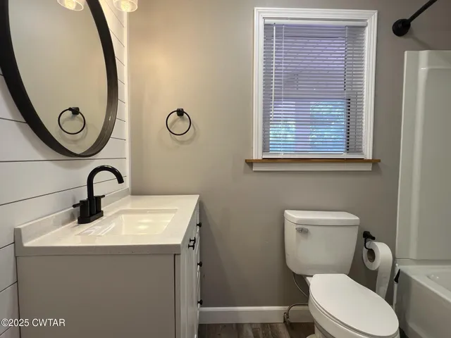 a bathroom with a toilet a sink and a mirror