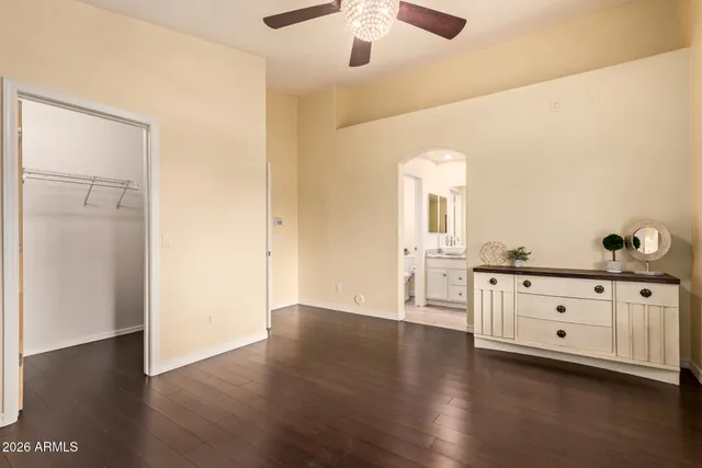 a large space with chandelier fan and wooden floor