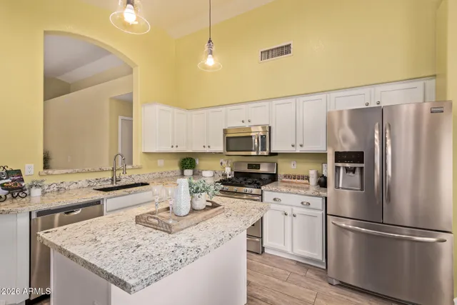 a kitchen with stainless steel appliances granite countertop a refrigerator stove microwave and sink