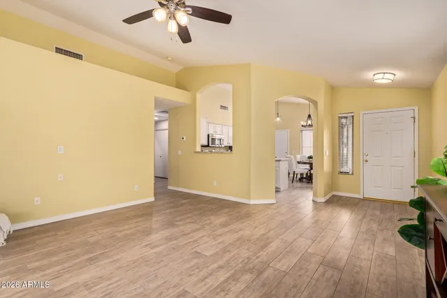 a view of a livingroom with a furniture wooden floor and a ceiling fan