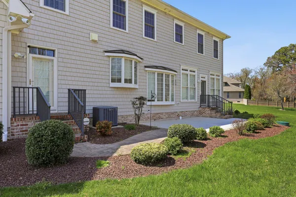 a front view of a house with a garden and plants