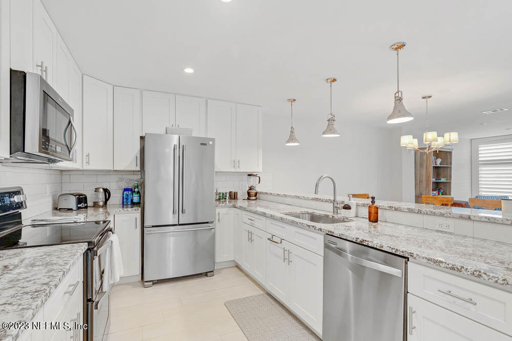 10 Cove Road Ponte Vedra Beach, FL 32082 - Photo 11 of 31 a kitchen with a sink a refrigerator a stove and cabinets