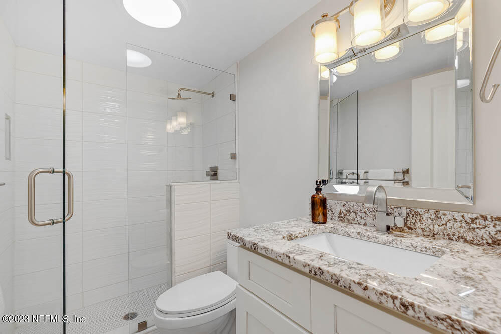 10 Cove Road Ponte Vedra Beach, FL 32082 - Photo 18 of 31 a bathroom with a granite countertop sink a toilet and shower