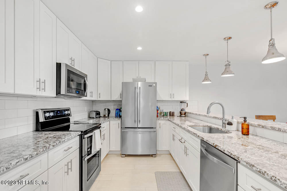 10 Cove Road Ponte Vedra Beach, FL 32082 - Photo 10 of 31 a kitchen with a sink stainless steel appliances and white cabinets