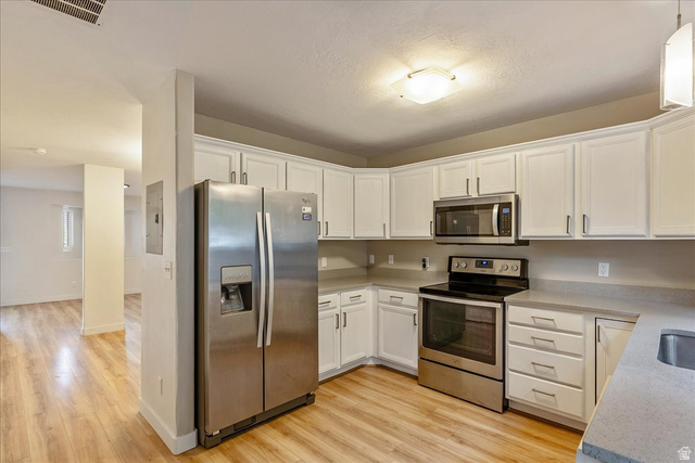 38 South 1000th Street East Payson, UT 84651 - Photo 11 of 19 Kitchen featuring stainless steel appliances, abundant white cabinetry, and wood-finish flooring