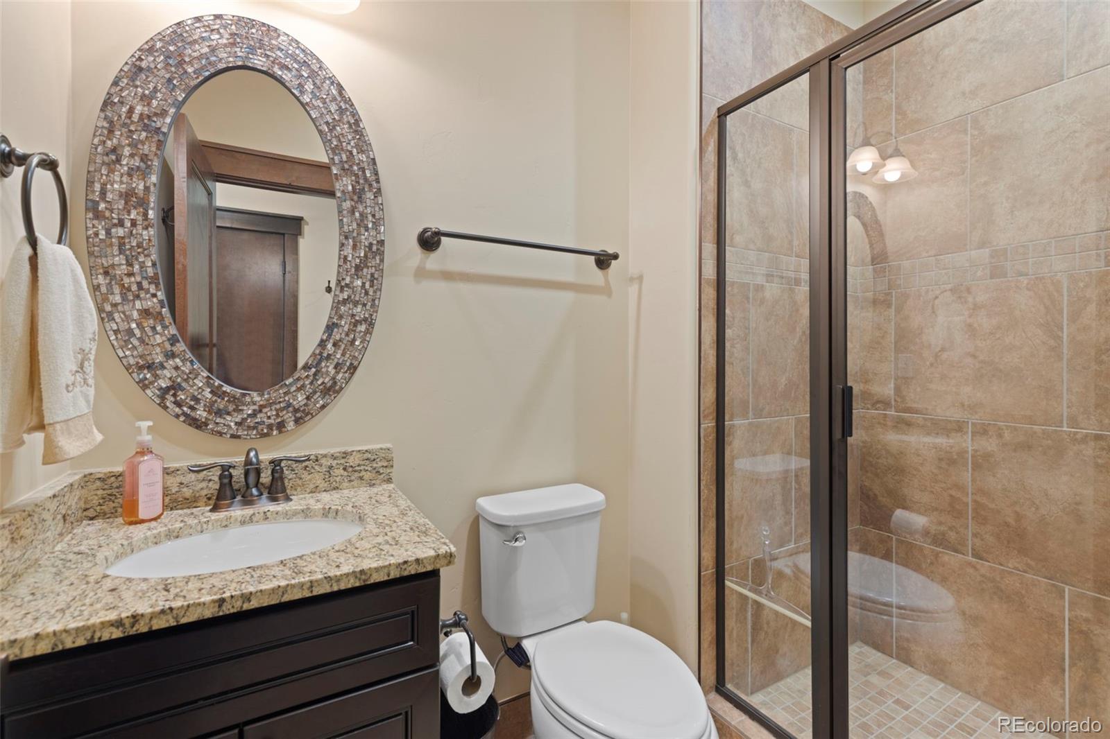 799 Independence Road Keystone, CO 80435 - Photo 20 of 44 a bathroom with a granite countertop toilet a sink and mirror
