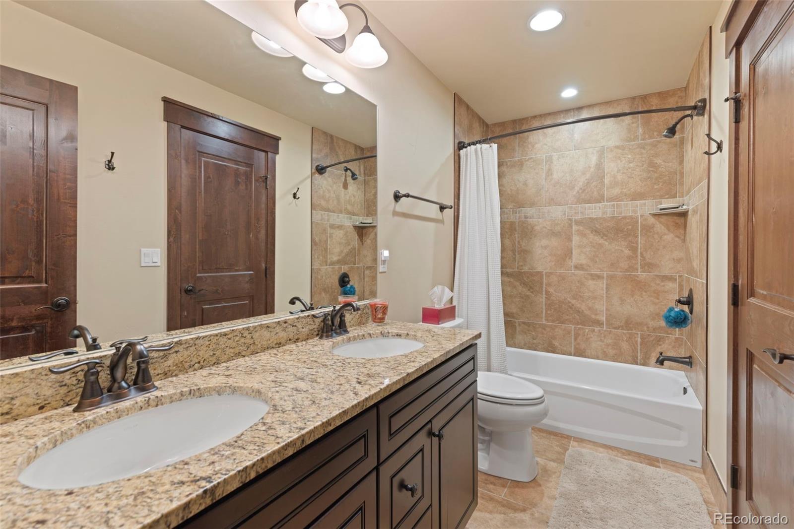 799 Independence Road Keystone, CO 80435 - Photo 40 of 44 a bathroom with a granite countertop sink a toilet a mirror and shower