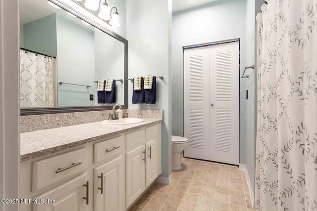 a bathroom with a double vanity sink a toilet and a mirror