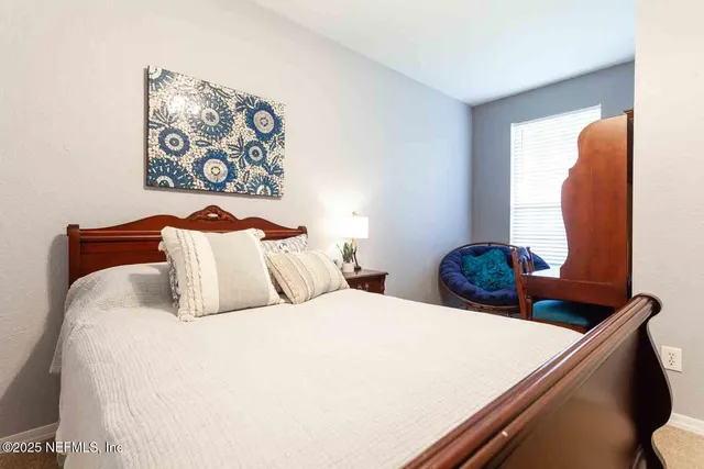 a bedroom with a bed and painting on the wall