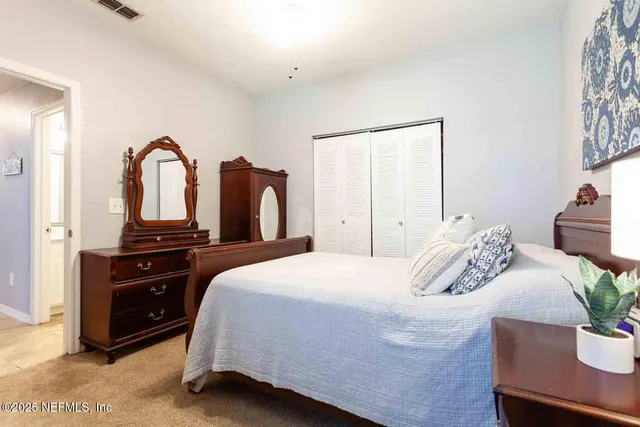 a bedroom with a bed and a potted plant