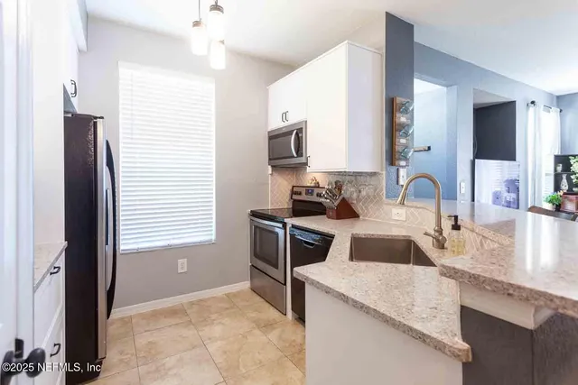 a kitchen with kitchen island granite countertop a sink stove and cabinets