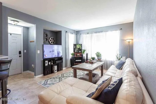 a living room with furniture a fireplace and a flat screen tv