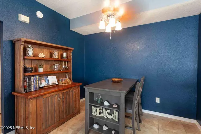a view of a dining room with furniture and chandelier