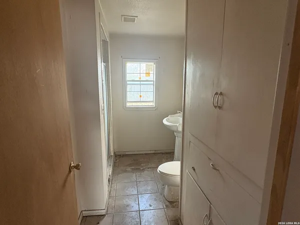 a bathroom with a granite countertop toilet and a sink