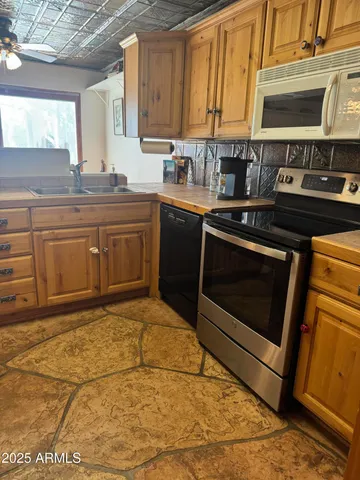 a kitchen with stainless steel appliances granite countertop a stove a sink and a microwave