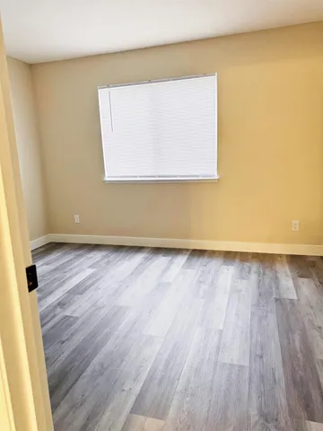 a view of a room with wooden floor and a window