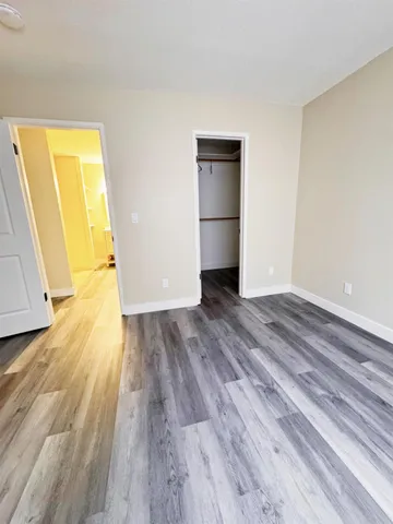 a view of empty room with wooden floor and entrance