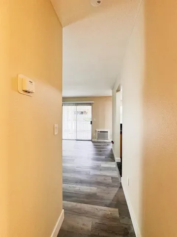a view of a hallway with wooden floor