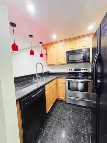 a kitchen with granite countertop a stove and a sink