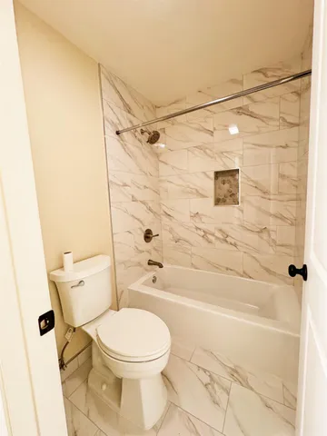 a bathroom with a toilet and shower