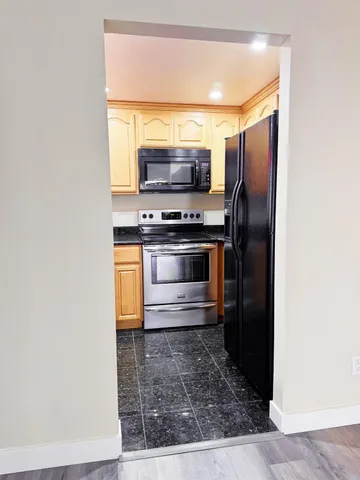 a kitchen with stainless steel appliances granite countertop a stove a microwave and a refrigerator