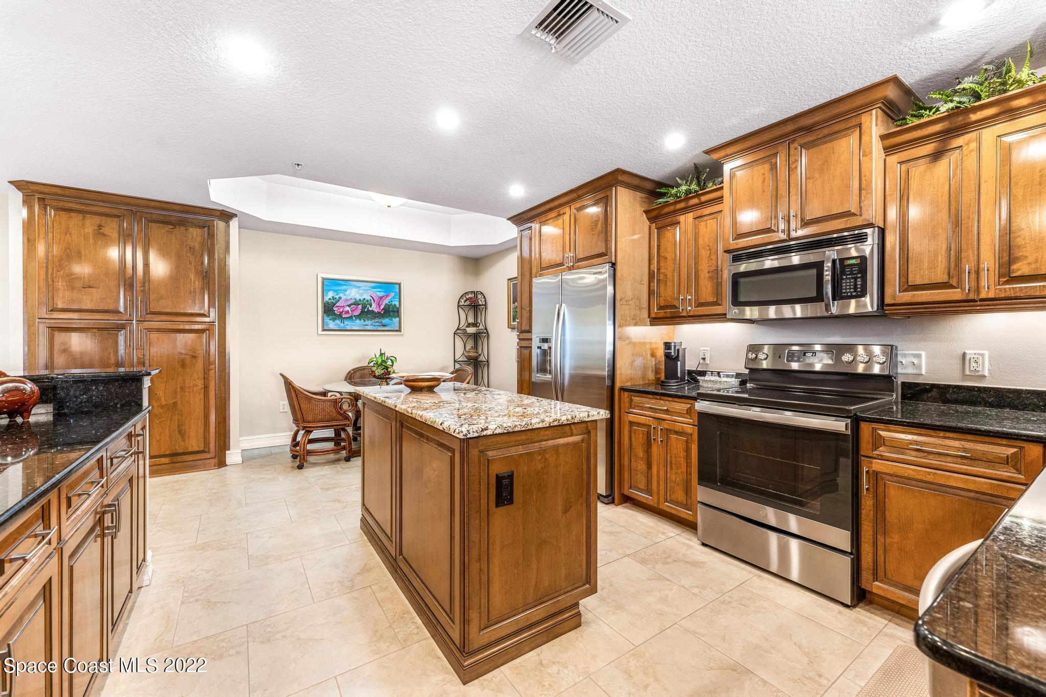 29 Riverside Drive, Unit 302 Cocoa, FL 32922 - Photo 12 of 56 a kitchen with stainless steel appliances granite countertop a stove top oven a sink a counter space and cabinets