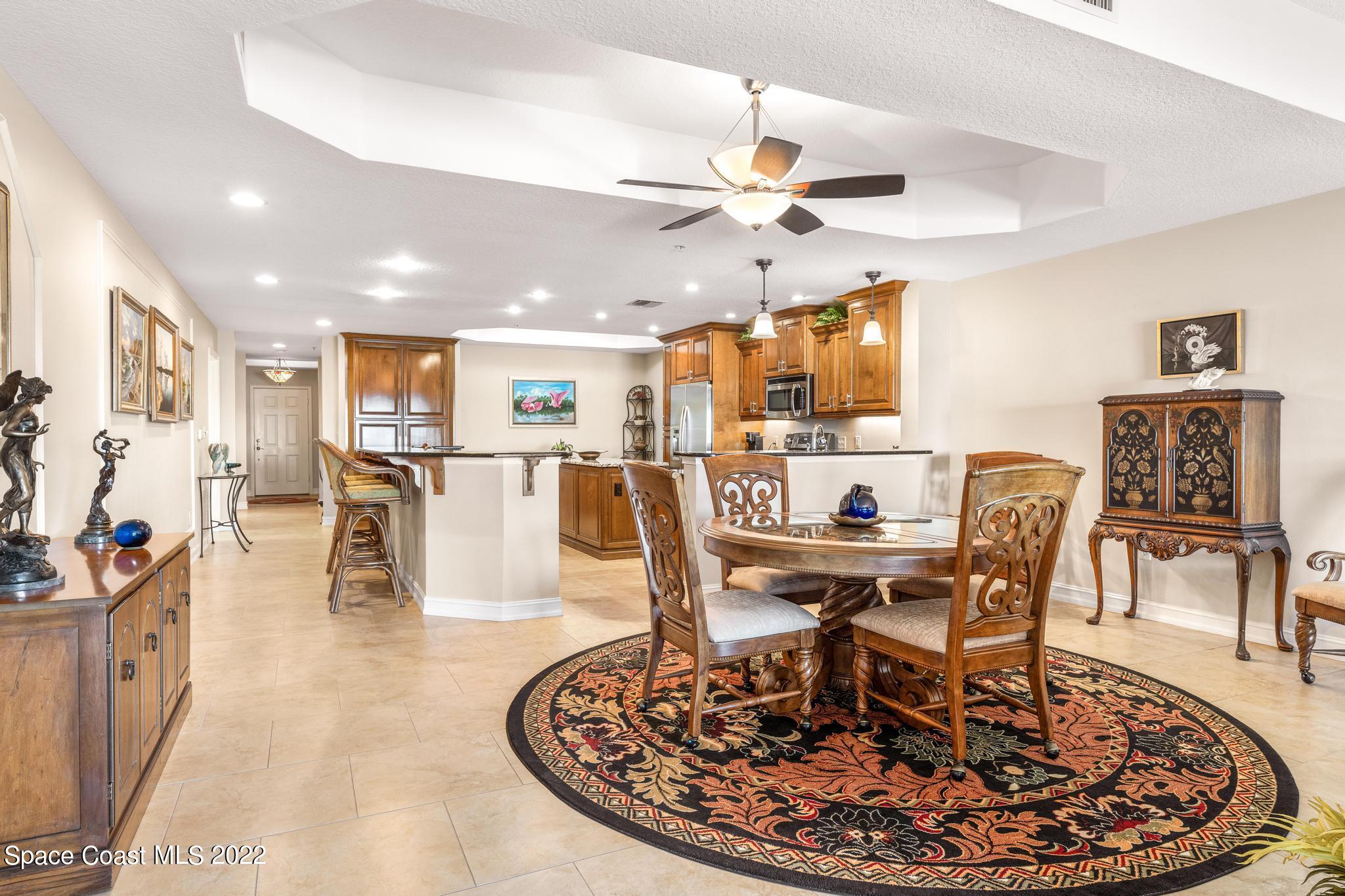 29 Riverside Drive, Unit 302 Cocoa, FL 32922 - Photo 16 of 56 a living room with dining table and a chandelier
