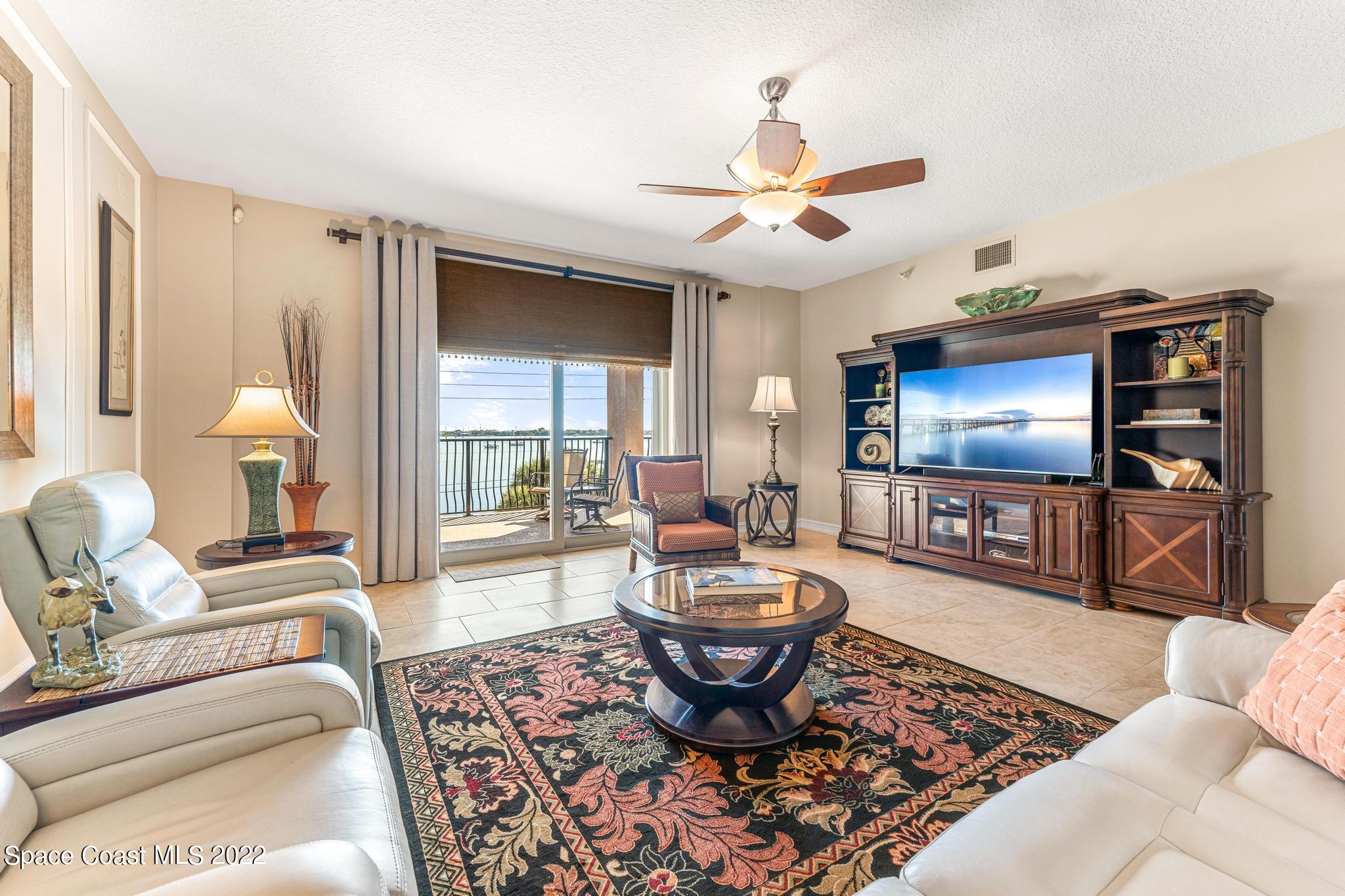 29 Riverside Drive, Unit 302 Cocoa, FL 32922 - Photo 19 of 56 a living room with furniture a ceiling fan and a flat screen tv