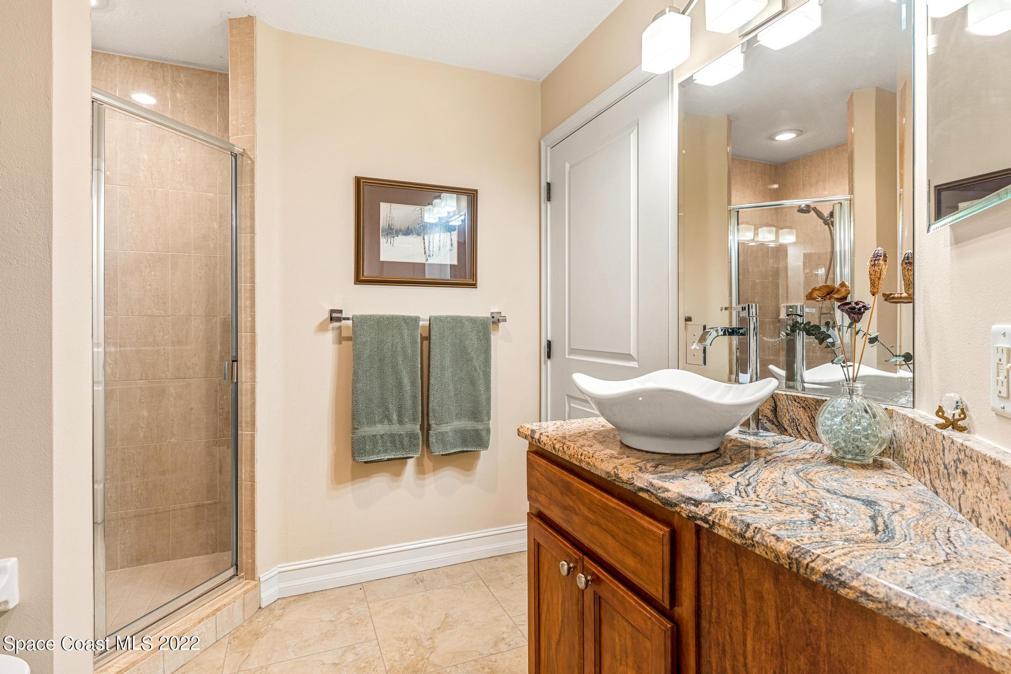 29 Riverside Drive, Unit 302 Cocoa, FL 32922 - Photo 25 of 56 a spacious bathroom with a granite countertop sink and a mirror