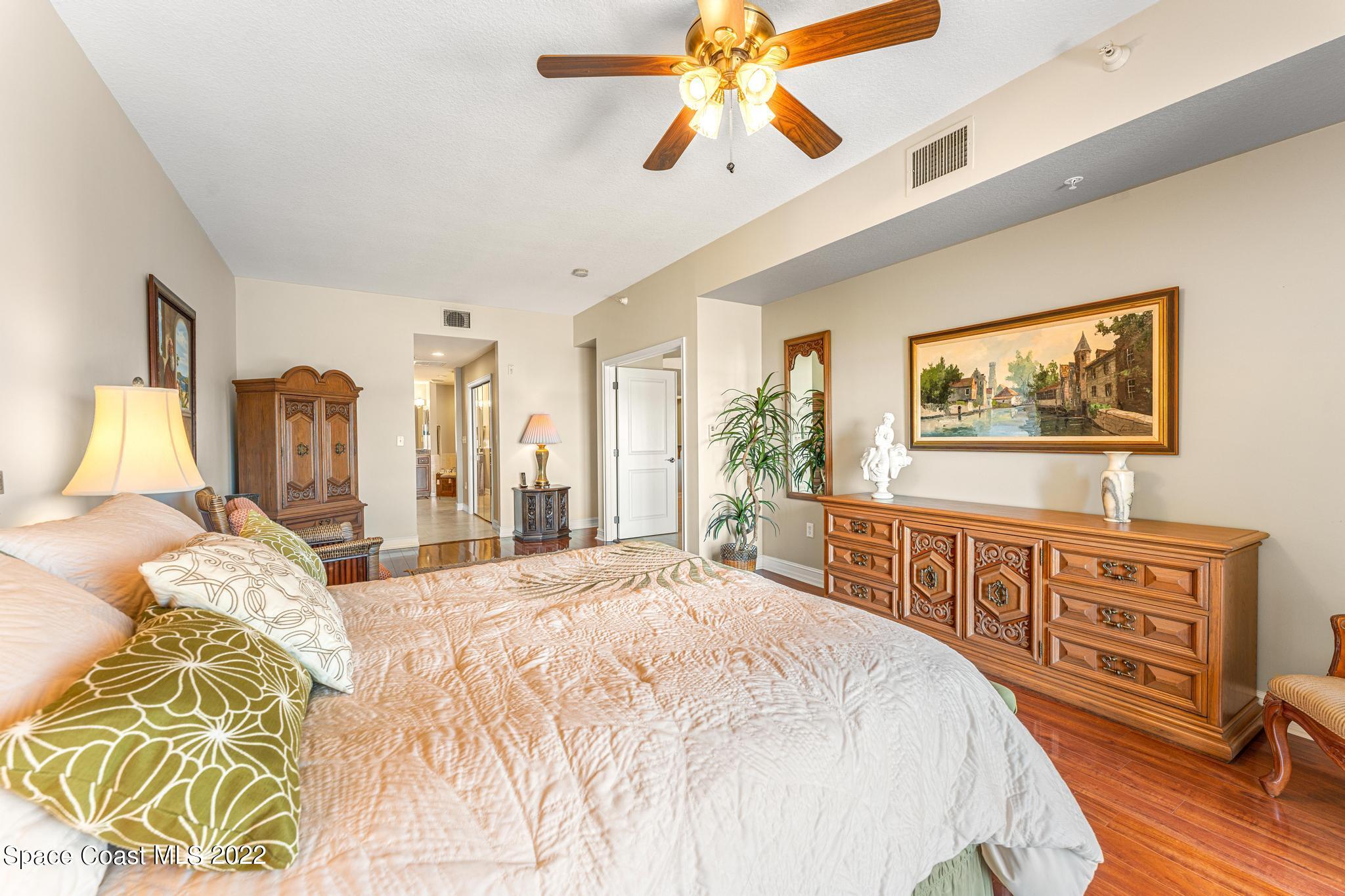 29 Riverside Drive, Unit 302 Cocoa, FL 32922 - Photo 29 of 56 a bedroom with a bed and a chandelier