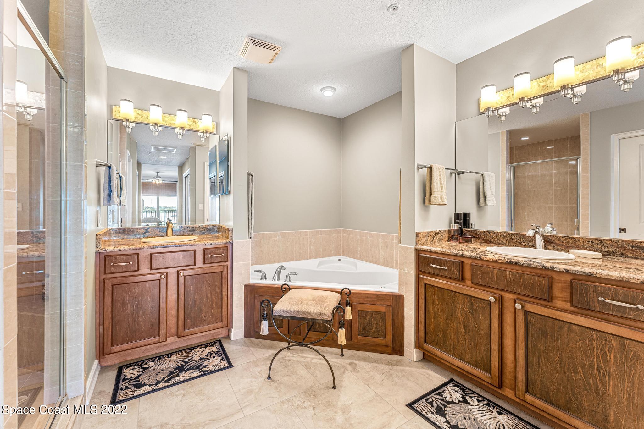 29 Riverside Drive, Unit 302 Cocoa, FL 32922 - Photo 31 of 56 a bathroom with a tub a sink double vanity and a mirror