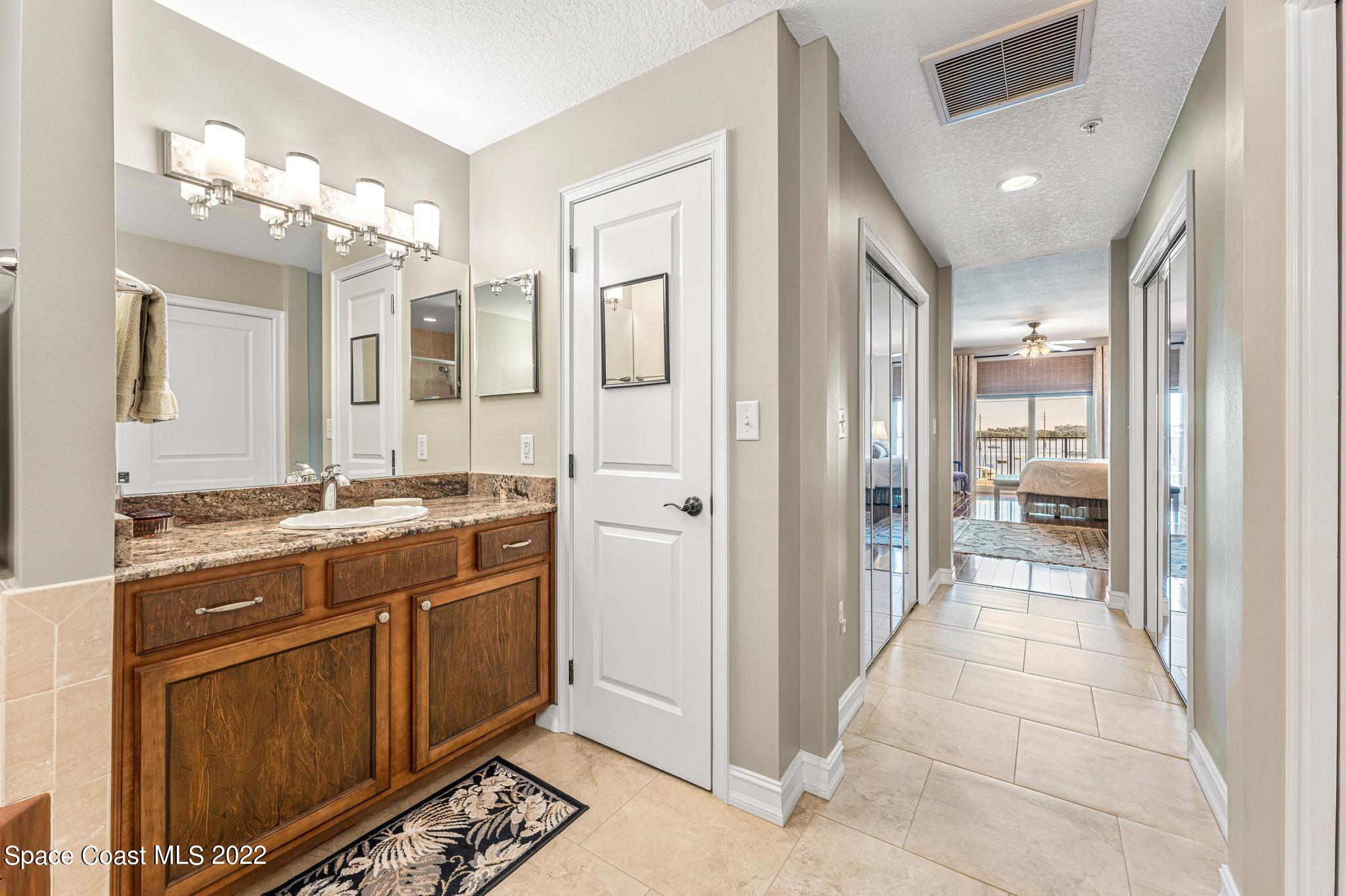 29 Riverside Drive, Unit 302 Cocoa, FL 32922 - Photo 32 of 56 a spacious bathroom with a granite countertop sink a mirror and a shower
